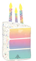 The 28" Holographic SuperShape Pearlized Birthday Foil Balloon by Anagram/MD is shaped like a rectangular cake with three lit candles, decorated in pastel hues with stars and confetti patterns.