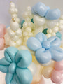 Un primer plano de ramos de globos con motivos florales elaborados con globos de látex 260G de Gemar en color «Marshmallow Powder Pink», con delicadas formas retorcidas sobre un fondo claro.