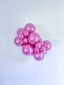 Un ensemble de ballons en latex Tuftex 36" Rockstar Chrome Like Effects (2 par sac) en rose métallisé brillant est groupé sur un fond blanc uni.